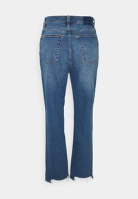 Modré džínové kalhoty s zadními kapsami a opranými lemy, zobrazené zezadu na bílém pozadí.