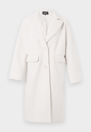 Manteau blanc, oversize en tissu texturé. Comprend des revers en pointe, des manches longues, deux poches plaquées et une fermeture à bouton unique.