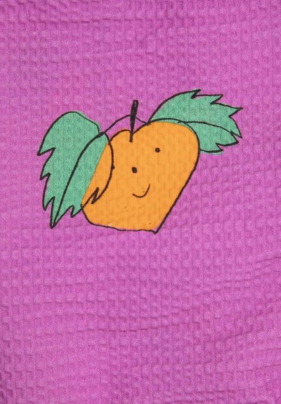 Fruit orange souriant avec deux feuilles vertes sur un fond en tissu violet texturé.