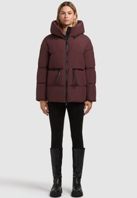 Chaqueta acolchada burdeos con capucha, cremallera frontal y dos bolsillos negros con cremallera. Fabricada con un material liso y acolchado; cuenta con un acabado elástico.