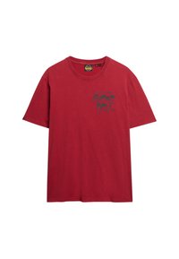 T-shirt in cotone rosso con maniche corte, presenta una stampa grafica nera che riporta la scritta "SUPER DRY" sull'angolo in alto a sinistra.