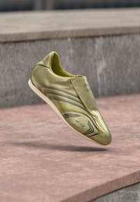 Kuldne jalgpallikets, millel on voolujooneline, aerodünaamiline disain. Siledast sünteetilisest materjalist pealmine osa, minimaalne õmbluste arv ja õhuke valge tald. Omab musta triibu aksente.