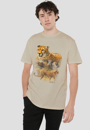 Beige cotton t-shirt featuring a detailed print of leopards and cheetahs in various poses, with a relaxed fit and short sleeves.