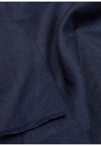 Donker marineblauwe stof met een gladde textuur, voorzien van subtiele weefpatronen en een gevouwen rand. Het materiaal lijkt lichtgewicht en flexibel.