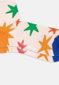 Bunte Socken mit einem hellen Hintergrund und Sternmustern in Grün, Orange, Rot und Pink. Mit weißem Branding "Dilly Socks".