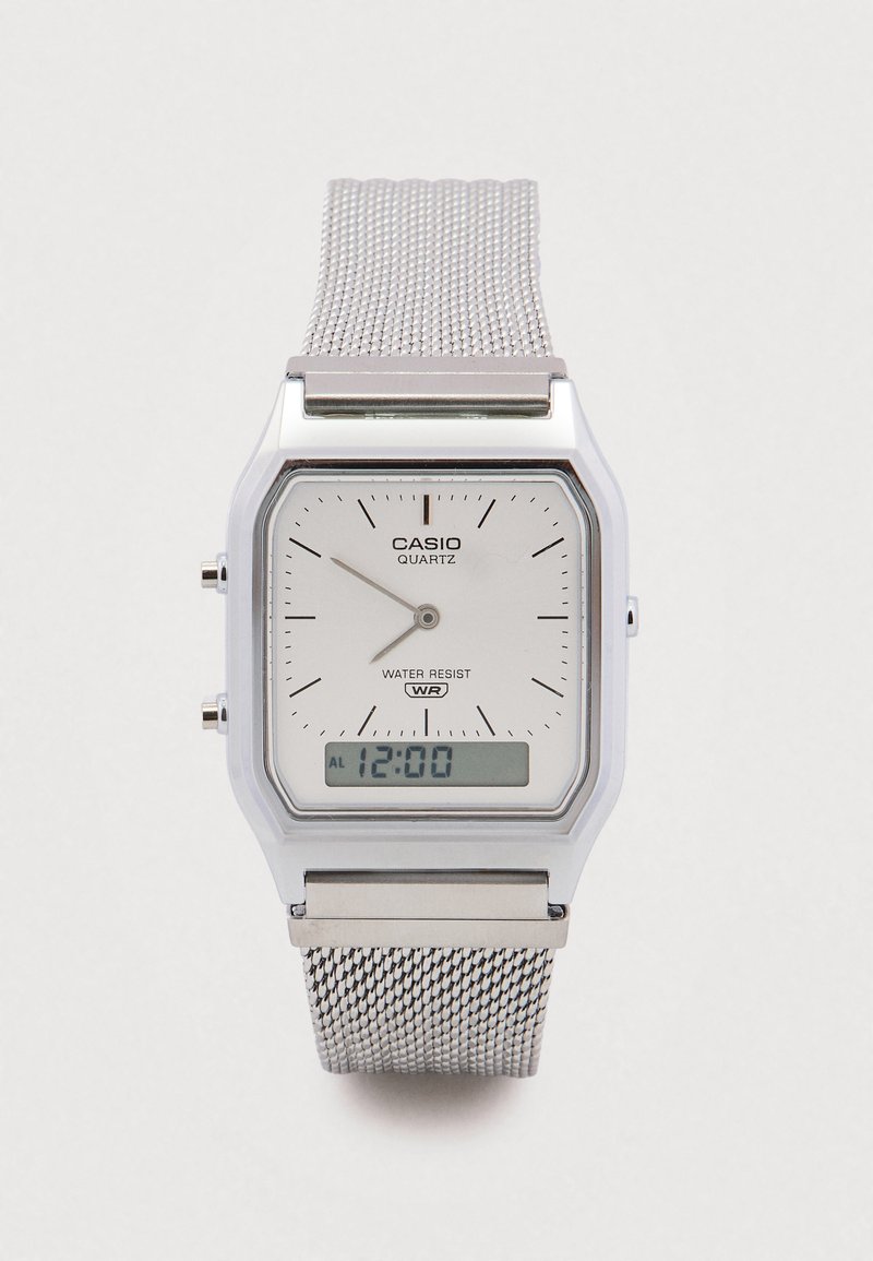 Srebrny zegarek Casio z mechanizmem kwarcowym, z prostokątną tarczą, białą tarczą główną, siateczkowym paskiem, czarnymi markerami minut oraz cyfrowym wyświetlaczem z funkcją alarmu.