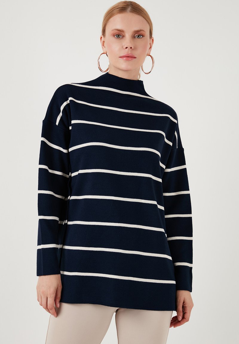 Pulover navy cu dungi orizontale albe, guler înalt și mâneci lungi. Fabricat dintr-un material moale cu o croială relaxată, având accente ribbed.