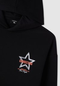 Felpa nera con cappuccio caratterizzata da una grande grafica di una stella argentata con il testo "CONNECTING" e uno slogan sottostante; tessuto morbido con vestibilità casual.