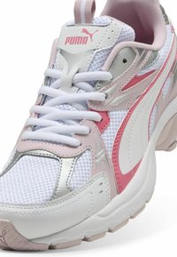 Zapatillas Puma de malla blanca con superposiciones sintéticas en rosa y plata. Punta redondeada, cuello acolchado y cordones blancos. Suela de goma texturizada.