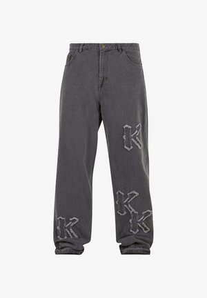 Sive ohlapne kavbojke z obrabljenimi vezenimi črkami "K" na levi stegni, desnem kolenu in levi gležnji.