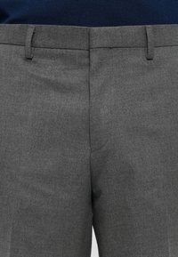 Graue maßgeschneiderte Hosen zeichnen sich durch eine glatte Textur mit einem subtilen Muster aus. Sie haben einen geraden Schnitt, Gürtelschlaufen und Taschen.