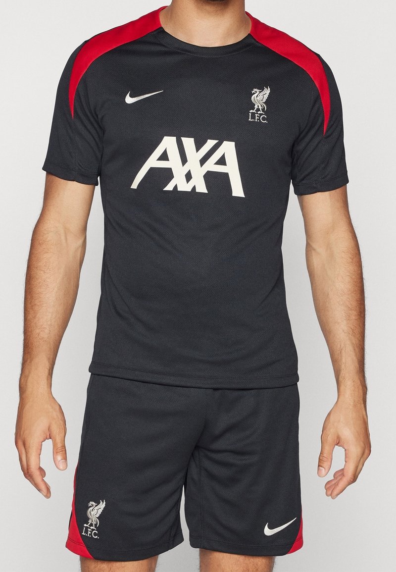 Svart atletisk tröja och shorts med röda accenter, med en vit Nike-logotyp och texten "AXA", samt Liverpool FC:s klubbemblem på shortsen.
