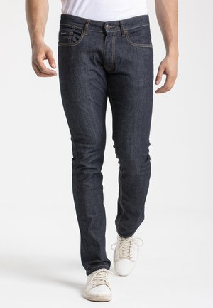 Jean en denim bleu foncé avec une coupe slim, présentant un design classique à cinq poches, des surpiqûres discrètes et une fermeture à bouton en métal.