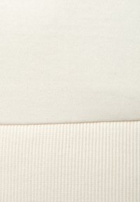 Cotton fabric in two tones: smooth white top section above a ribbed off-white bottom section. Texture variations highlight the design.