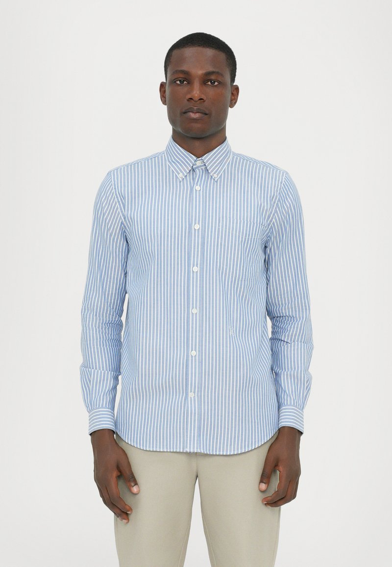 Camisa de botones a rayas de color azul claro y blanco, con cuello, mangas largas y un bolsillo en el lado izquierdo. Tejido de algodón suave.