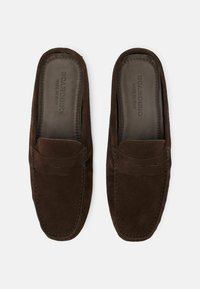 Smeđe suede cipele na vezanje s glatkom kožnom uloškom i dekorativnim šavovima. Okrugli vrh i suptilno uzdignuti detalji šavova.