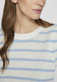 Jersey de punto con cuello redondo en blanco, con finas rayas horizontales azules. La textura es abierta y transpirable, con mangas cortas.