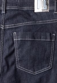 Jeans de mezclilla oscura con un bolsillo trasero que presenta costuras blancas. La etiqueta en la cinturilla muestra el nombre de la marca "Cecil."