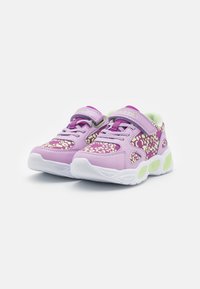 Lila sneakers med en texturerad design som har vita accenter och gröna detaljer. Kardborreband och snörning. Kraftig vit sula.