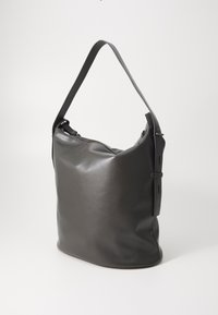 Sac hobo en cuir gris lisse avec une seule sangle ajustable, dotée d'une fermeture éclair supérieure et d'éléments de design minimalistes.