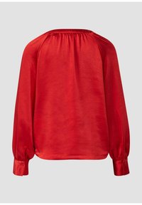 Rote Langarmbluse mit glatter, satinähnlicher Textur. Mit gerafften Details am Rücken und geknöpften Manschetten. Einfaches, tailliertes Design.