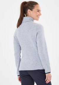 Helles grauer Fleece-Pullover mit hohem Kragen, langen Ärmeln und feiner Textur. Verf�ügt über Akzente in dunklem Marineblau an den Bündchen und dem Saum.