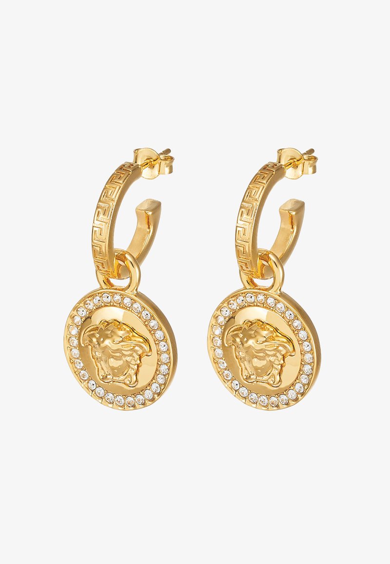 Brincos de argola em ouro com um design em destaque de cabeça de leão, rodeado por um aro circular. Acabados com pedras de strass transparentes para um detalhe adicional.