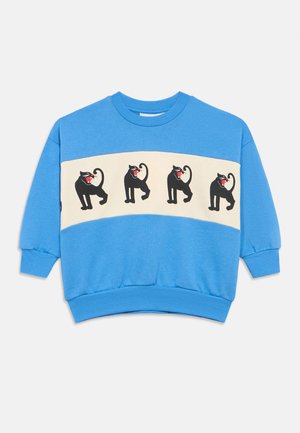 Sudadera de algodón azul con una banda de color crema que presenta cuatro gráficos de gatos negros con bocas rojas. Puños y dobladillo acanalados, escote redondo.