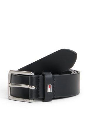 Ceinture en cuir noir avec boucle rectangulaire argentée et petit logo rouge, blanc et bleu sur la boucle de ceinture, enroulée sur un fond blanc.