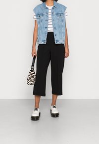 Džínová vesta, pruhované tričko, černé culottes, bílé boty s černými podešvemi, taška se zebřím vzorem. Neformální outfit v světlých a tmavých tónech.