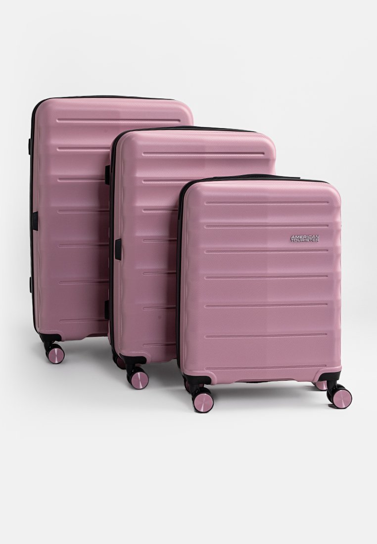 Tres maletas rígidas de color rosa con superficies texturizadas, estrías horizontales, cremalleras negras y cuatro ruedas para facilitar el movimiento. Las dimensiones van de pequeña a grande.