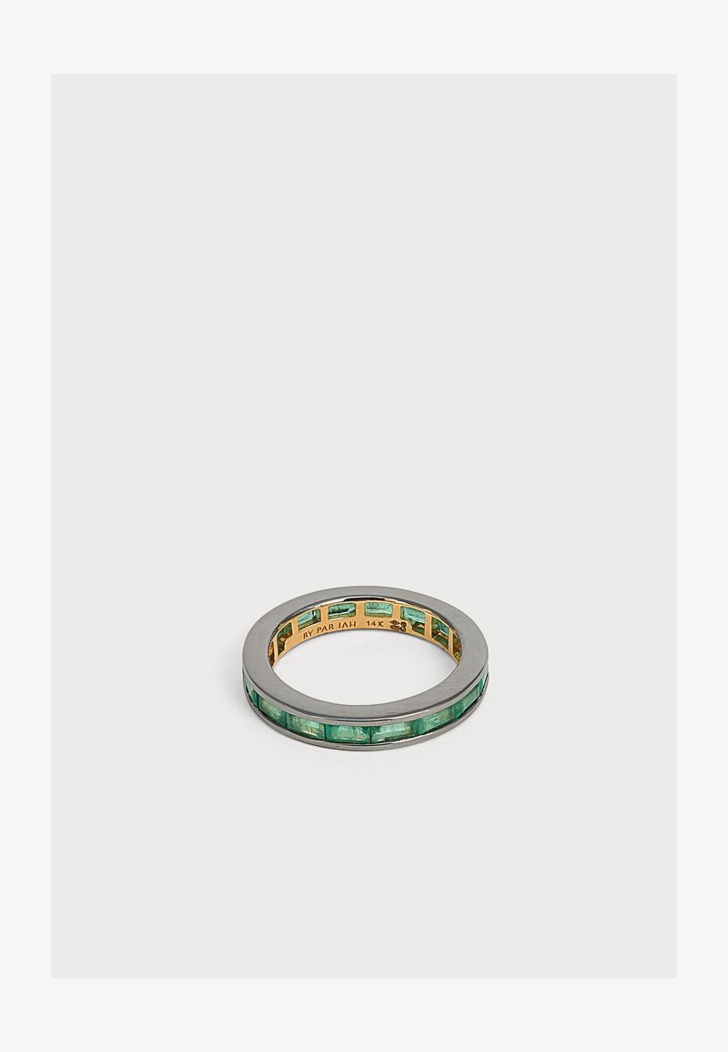 Bague fine bicolore avec des pierres précieuses vertes taillées en carré, serties autour d'une bande en or à l'intérieur d'un bord extérieur en argent.