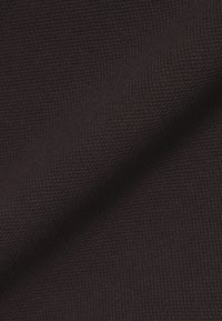 Dunkelbrauner Strickstoff mit strukturierter Oberfläche und einem Kreuzmuster. Das Material wirkt weich und etwas flexibel.