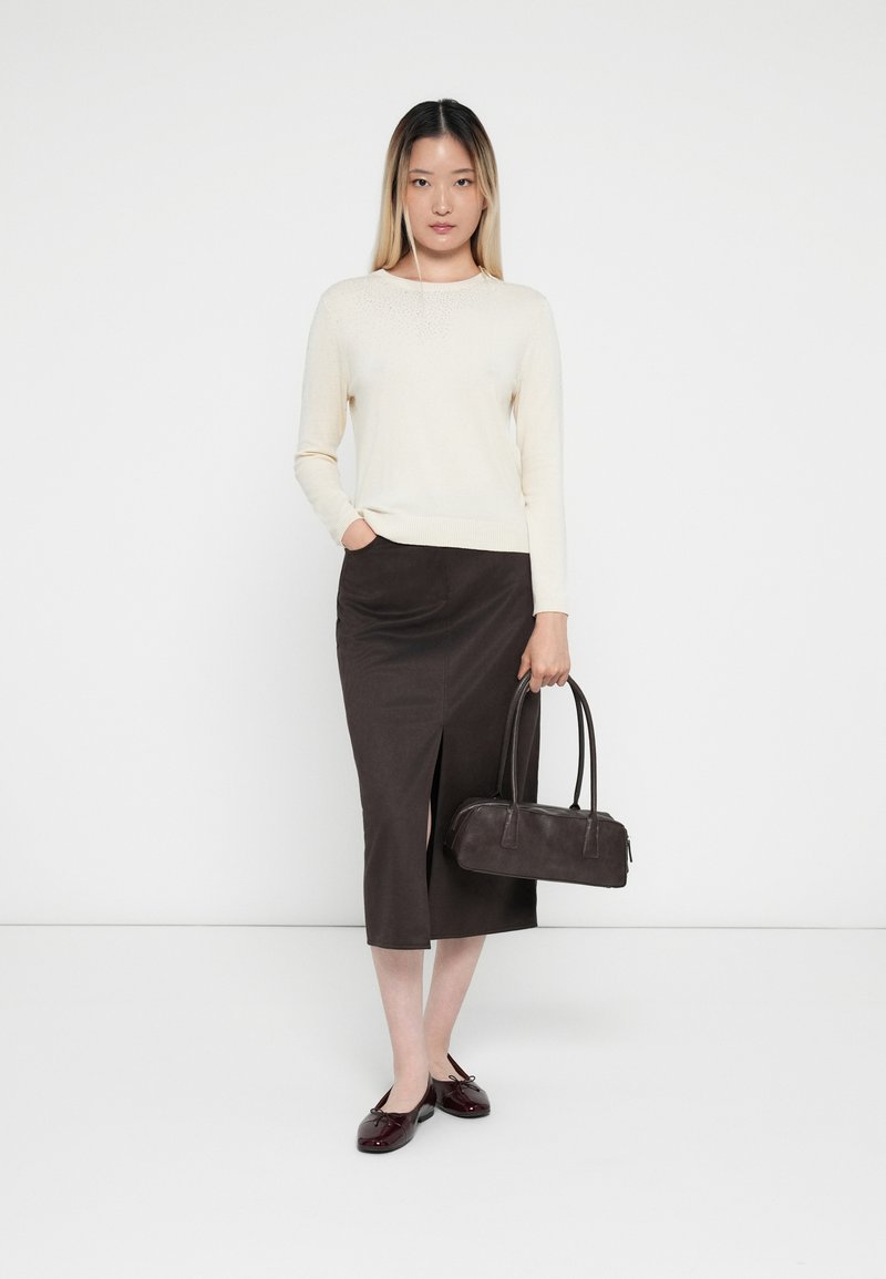 Suéter beige, falda midi marrón oscuro con abertura, bolso negro y zapatos burdeos. Texturas suaves, diseño casual, paleta de colores neutros.
