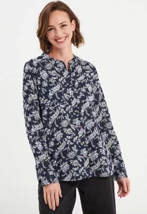 Navybluse mit weißem Blumenmuster, Knöpfen auf der Vorderseite, langen Ärmeln und Stehkragen; aus leichtem Stoff gefertigt.