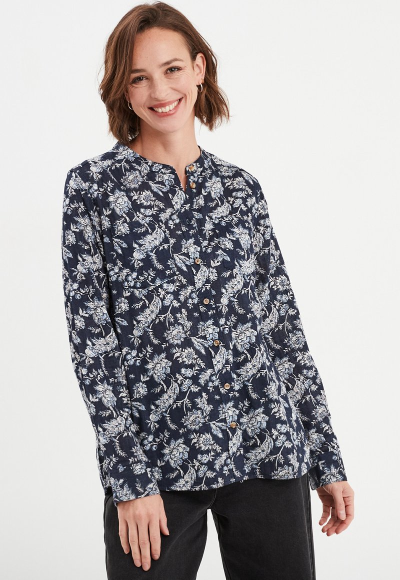 Blusa navy con patrón floral blanco, botones en la parte delantera, mangas largas y cuello mao; fabricada en tela ligera.
