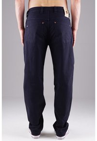 Dark navy cargo pants with a relaxed fit, featuring two back pockets and a branded leather patch on the waist. Cotton material.