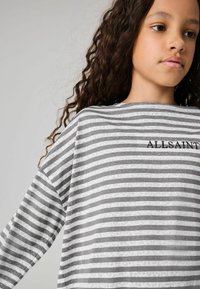 Šedá a biela pruhovaná košeľa s dlhým rukávom a voľným strihom, s vyšívaným logom "ALLSAINTS" na prednej strane, s jemnou textúrou látky.