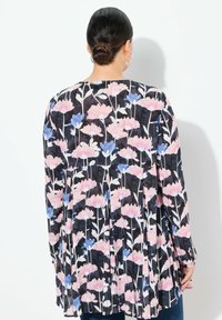 Langärmlige Bluse aus schwarzem Stoff mit einem floralen Muster in Pink und Blau. Gefälteltes Rückendesign mit rundem Halsausschnitt.