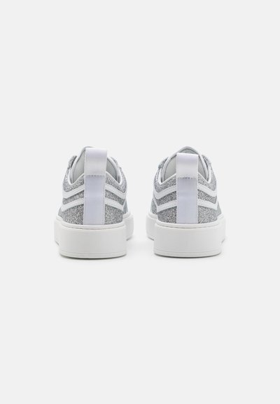 Zapatillas plateadas con purpurina, suela de goma blanca, tejido suave y detalles texturizados. Tab de agarre trasero y franjas laterales en contraste.