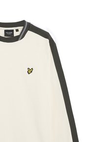 Maglione crema con accenti verde scuro, collo a giro, e polsini a costine. Presenta un logo ricamato giallo sul petto sinistro. Tessuto morbido.
