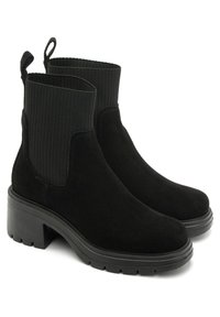 Black suede ankle boots feature a ribbed elastic side panel, rounded toe, and chunky heel with a textured sole for added grip.
