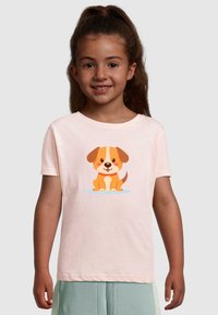 Helles rosa T-Shirt mit kurzen Ärmeln aus Baumwolle, mit einer Cartoon-Hund-Illustration in Orange und Weiß auf der Vorderseite.