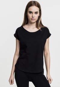 T-shirt noir à manches courtes en tissu doux, avec un col rond et une coupe décontractée. Design simple, sans motifs ni ornements.