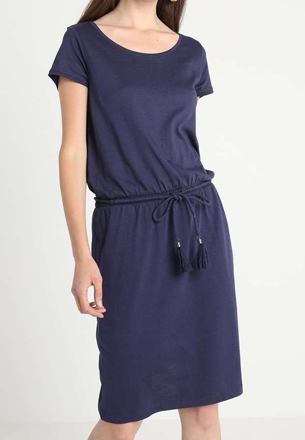 Robe bleu marine en tissu doux, avec des manches courtes, un col rond et une taille élastique avec un cordon de serrage et des accents de pompons.