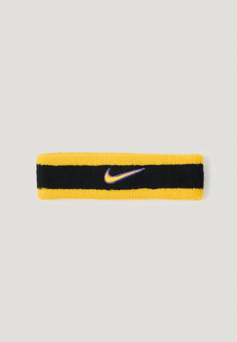 Faixa de cabeça da Nike com um design riscado em amarelo e preto, feita de tecido texturizado, com um pequeno logótipo swoosh roxo.
