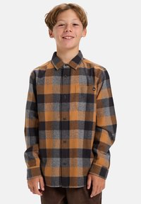Overhemd met knoopsluiting in een geruite print met oranje, grijze en zwarte kleuren; gemaakt van zacht stof met lange mouwen en een borstzak.