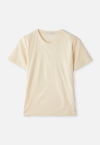 Cream-colored T-shirt made of soft, lightweight cotton, featuring short sleeves and a round neckline. No visible patterns or accents.