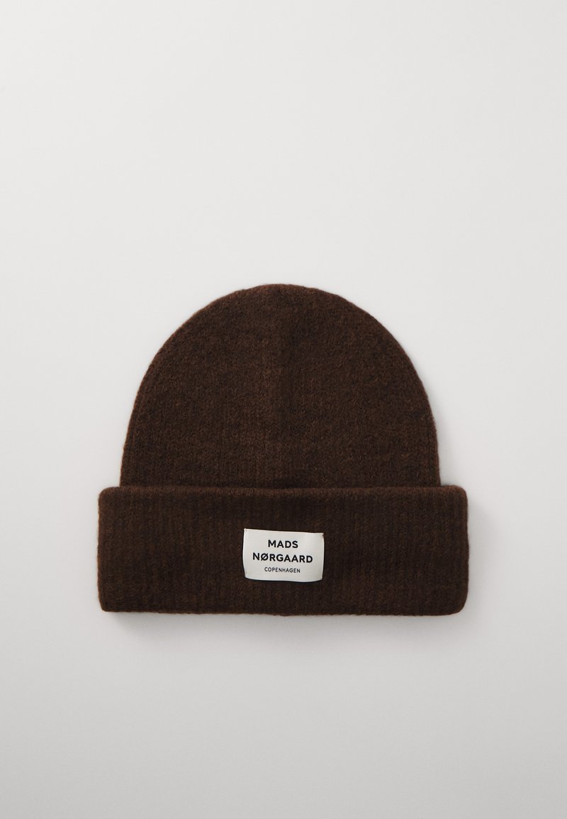 Bonnet tricoté marron avec un revers, portant une étiquette blanche affichant "MADS NØRGAARD COPENHAGUE." Matériau texturé et chaud.