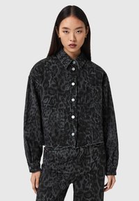 Μαύρο τζιν μπουφάν με μοτίβο λεοπάρδαλης, κλείσιμο με κουμπιά μπροστά, δύο τσέπες στο στήθος και κοντή σχεδίαση με ελαφρώς φθαρμένο τελείωμα.